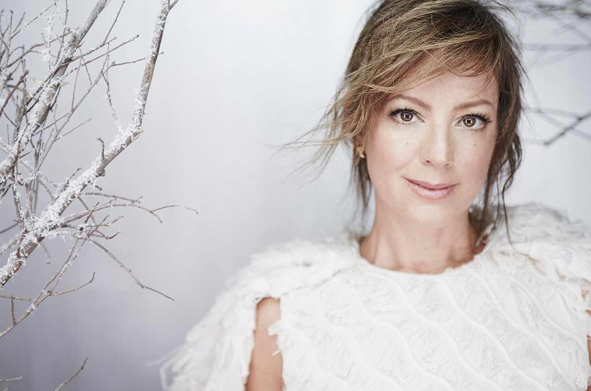 Sarah McLachlan memakai baju putih, berpose menghadap kamera, dengan setting ala salju.